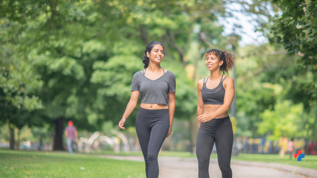 Two women walking outdoors—stress management tips like movement and social support to help improve sleep and overall resilience.