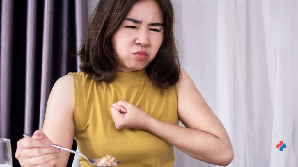 Woman experiencing chest discomfort after eating, showing possible heartburn symptoms.